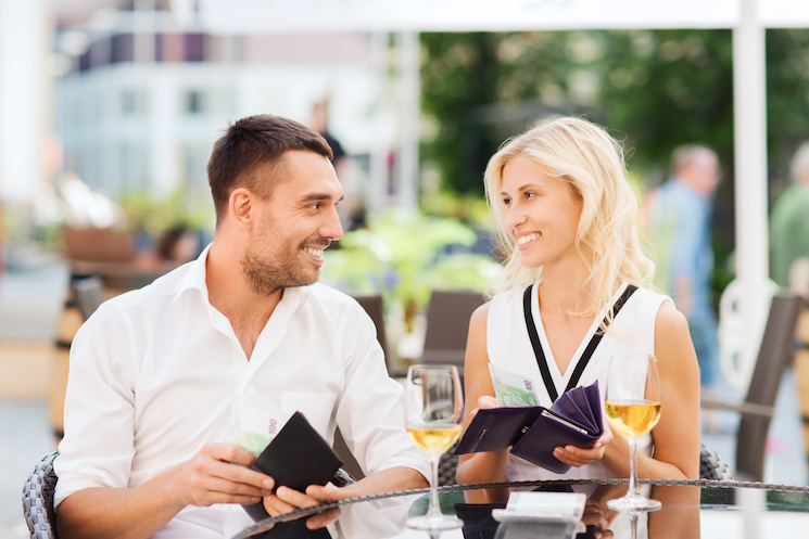 happy couple with wallet paying bill at restaurant