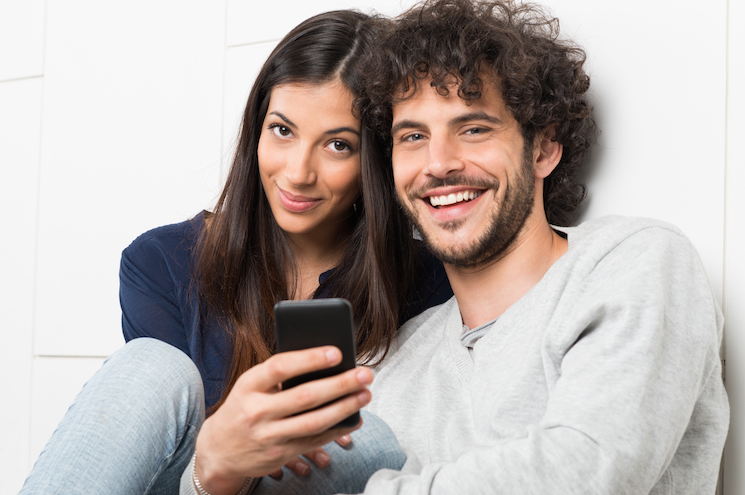 Happy Couple Holding Cellphone